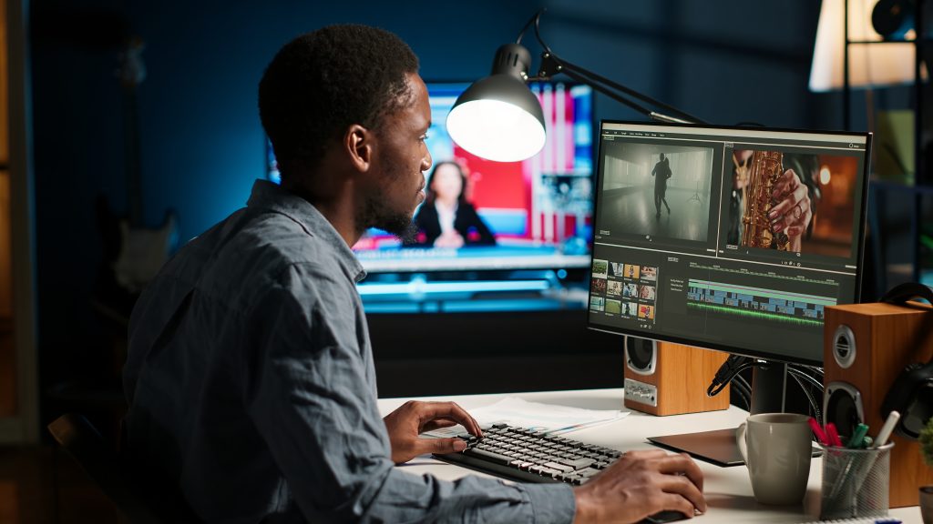 african american videographer works editing film footage home
